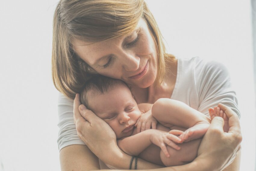 woman in white crew neck t-shirt carrying baby